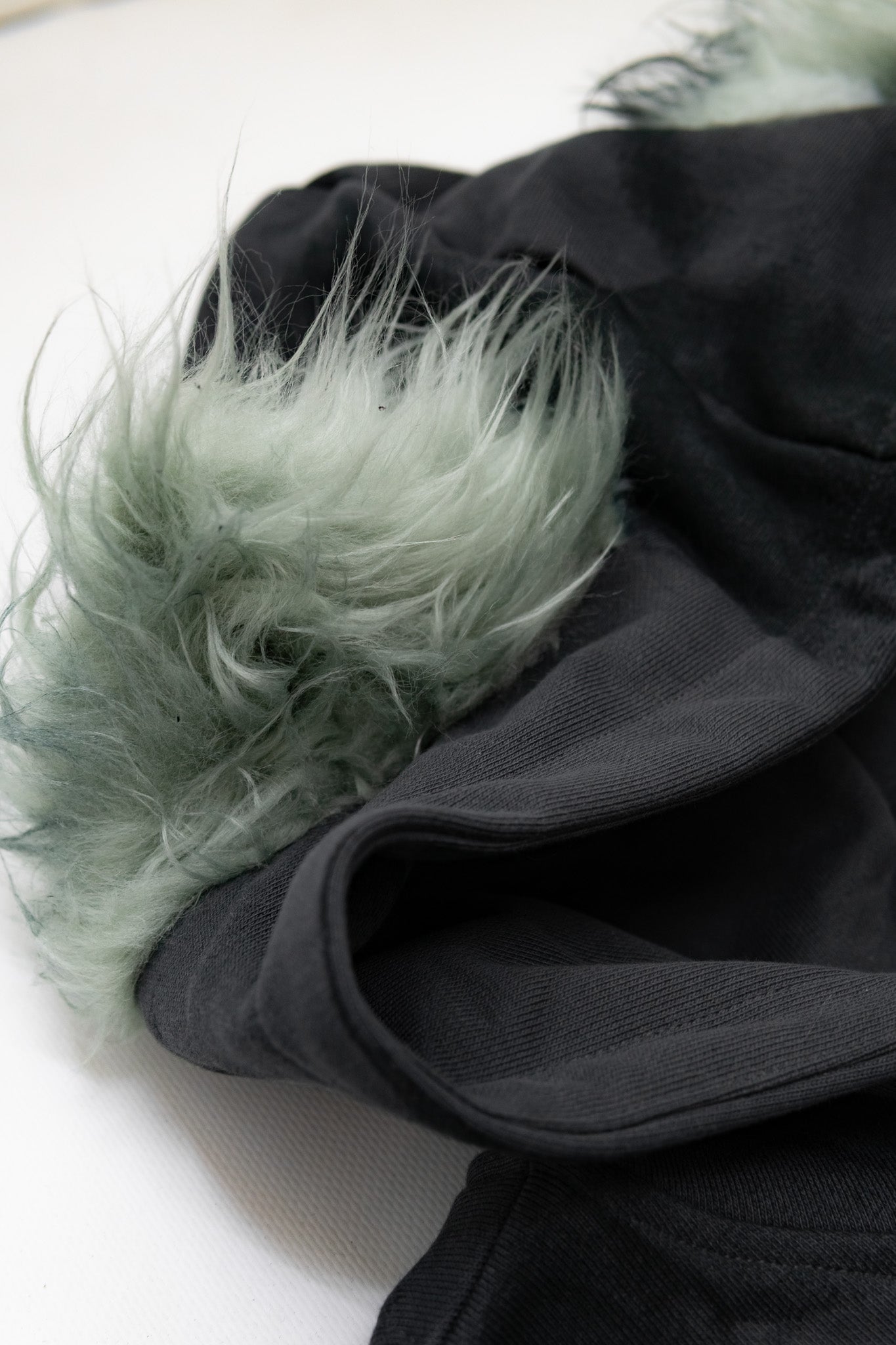 Detailansicht der Kapuze mit den aus Kunstfell gefertigten Katzenohren – Einzigartiges Design-Detail.