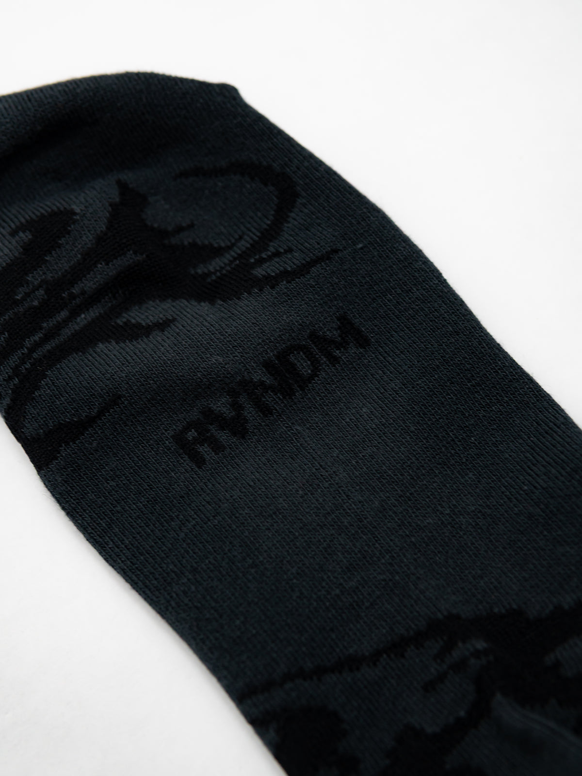 Nahaufnahme des eingewebtem RVNDM Schriftzugs auf der Sole der Socken.